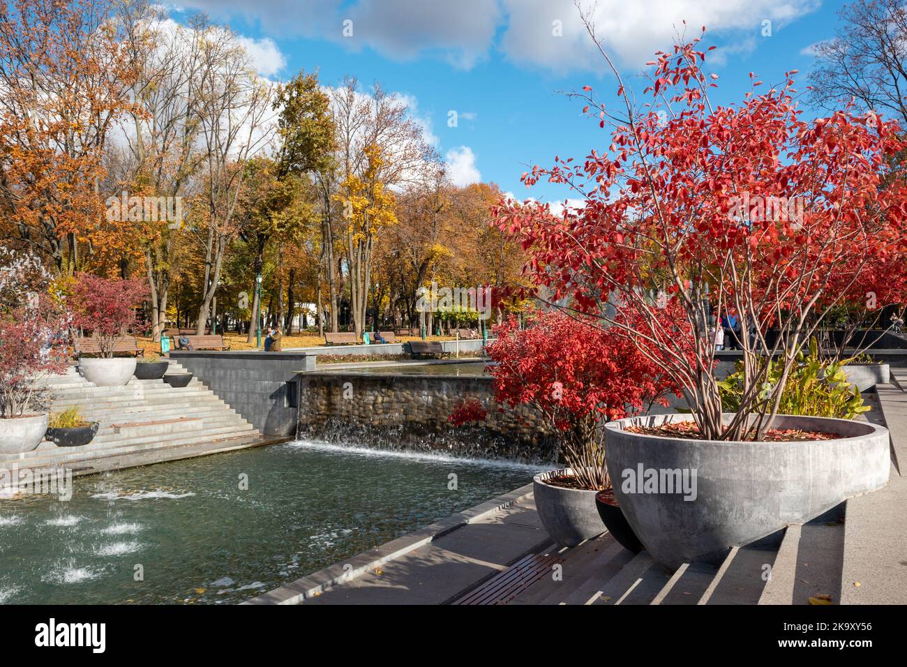 Cascade fountains waterfall in Shevchenko City Garden with red autumn trees. Tourist attraction in central city park, Kharkiv Ukraine Stock Photo