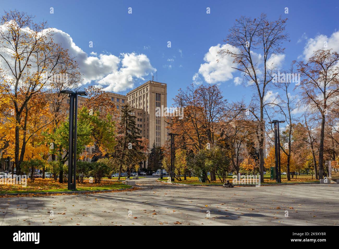 Autumn city center streets, V.N. Karazin Kharkiv National University building in colorful golden trees and blue sky, Ukraine Stock Photo
