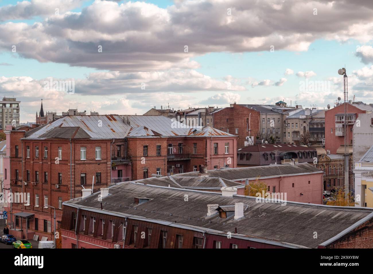 Kharkiv city center red brick houses street rooftop. Old weathered residential buildings with scenic cloudscape in Kharkiv downtown, Ukraine Stock Photo