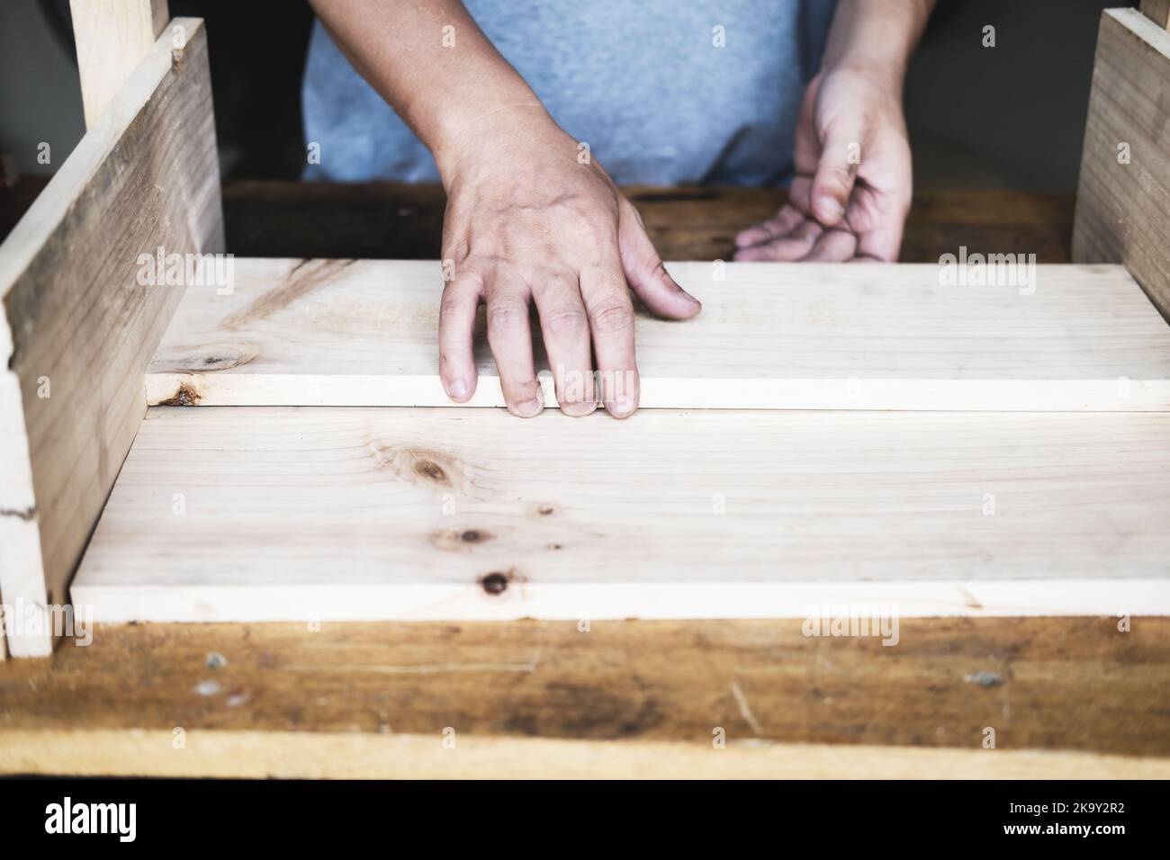 A carpenter measures the planks to assemble the parts, and build a