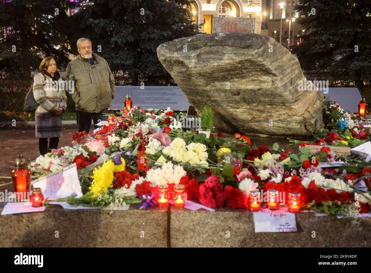The monument for the victims of political terror in the Soviet Union in Lubyanka Square, Moscow. The stone from the Solovetsky Islands in the White Sea was placed here in 1990, opposite of the headquarters of the Soviet secret service KGB, now of its successor. People have brought flowers and candles in commemoration of the victims. In 2022, the usual ceremony of reading the victims' names was prohibited by the authorities. Stock Photo