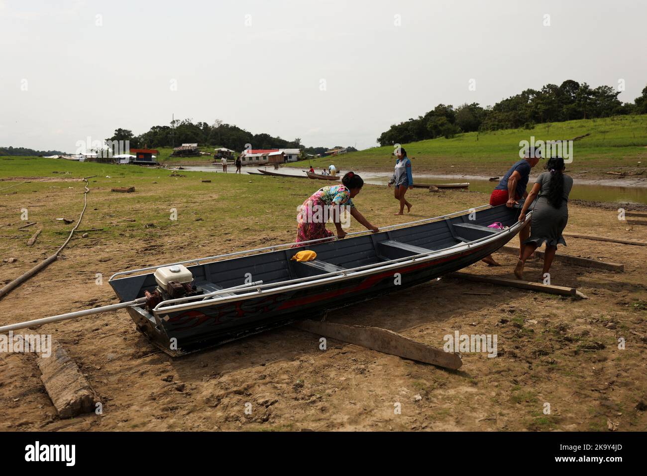 People move their boat over a sandbank next to the shallow Negro river to cast their votes at a polling station, in the Catalao community, in Iranduba, Amazonas state, Brazil October 30, 2022. REUTERS/Bruno Kelly Stock Photo