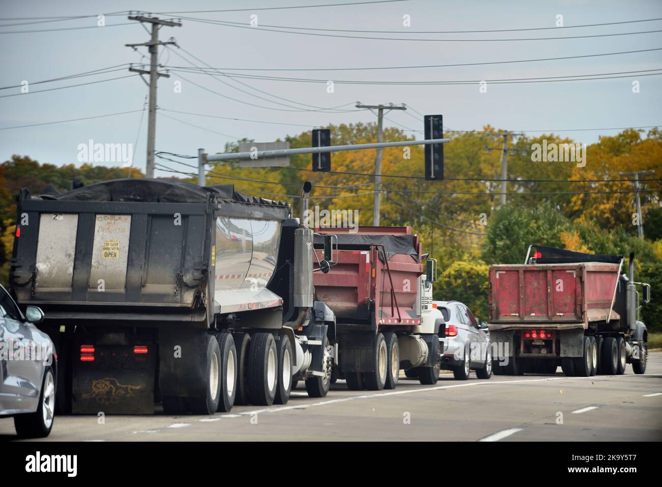 Streamwood, Illinois, USA. Dump trucks stopped at an intersection waiting to make left turns. Stock Photo