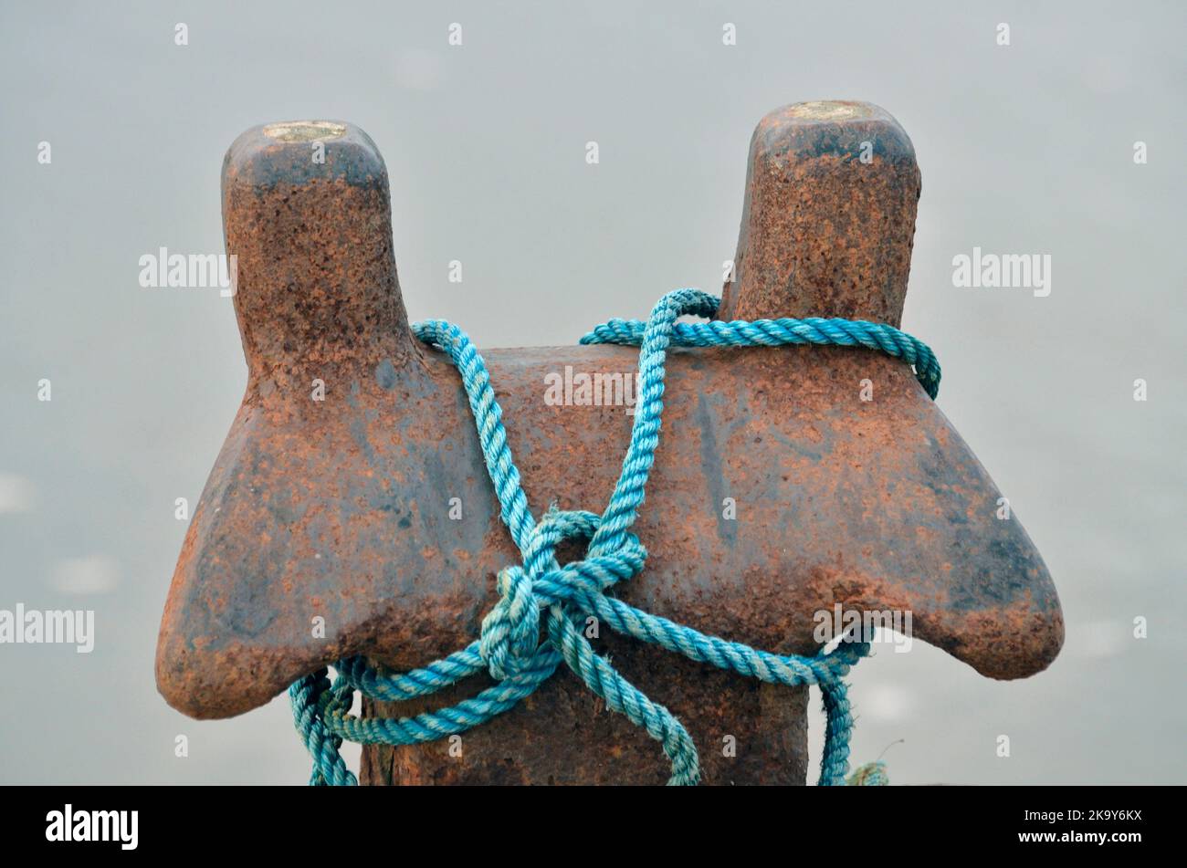 blue synthetic mooring rope wound round wound weathered mooring bollard