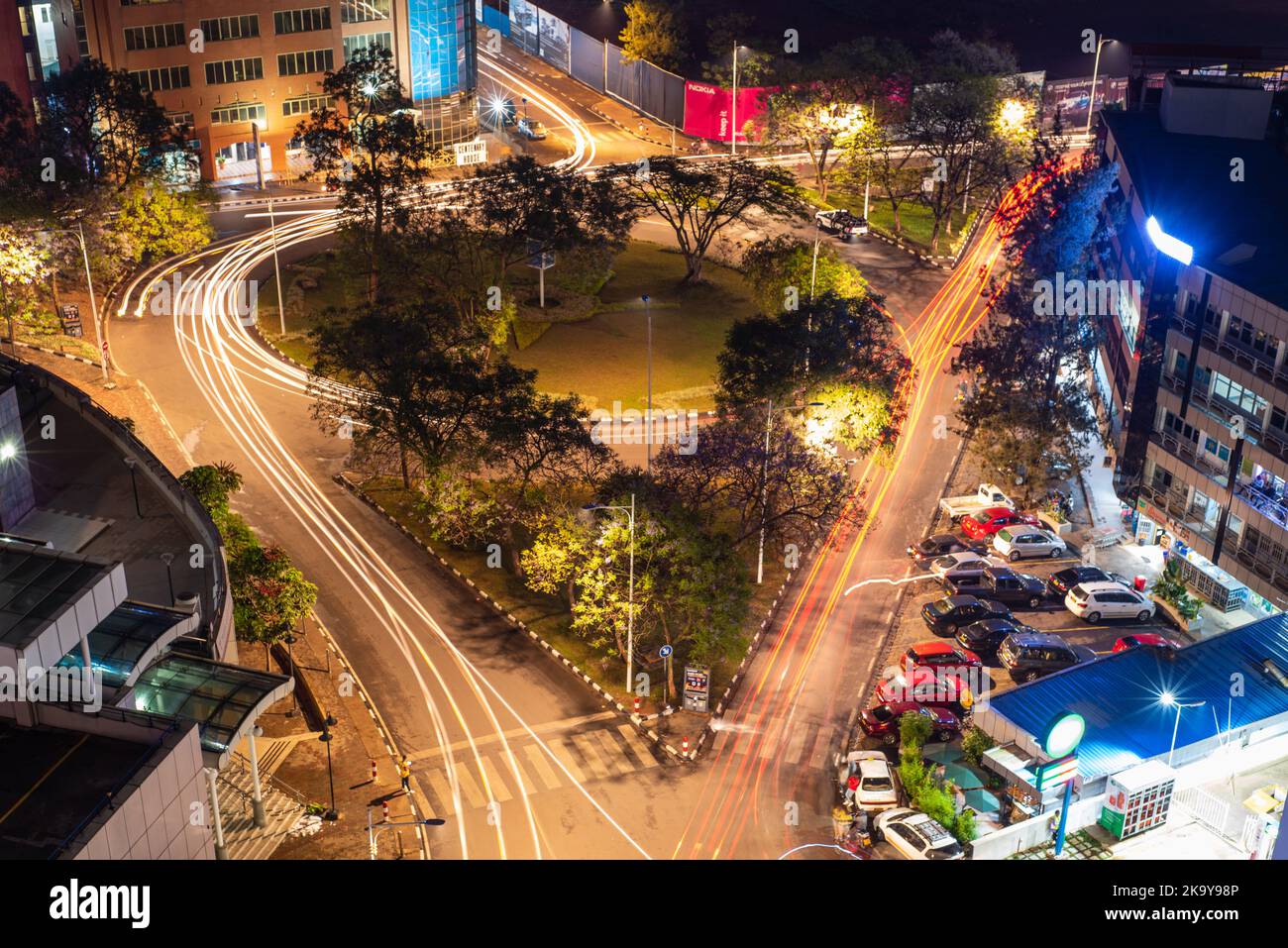 Kigali, Rwanda - August 17 2022: Roundabout in the heart of the city centre at night, surrounded by buildings. Stock Photo