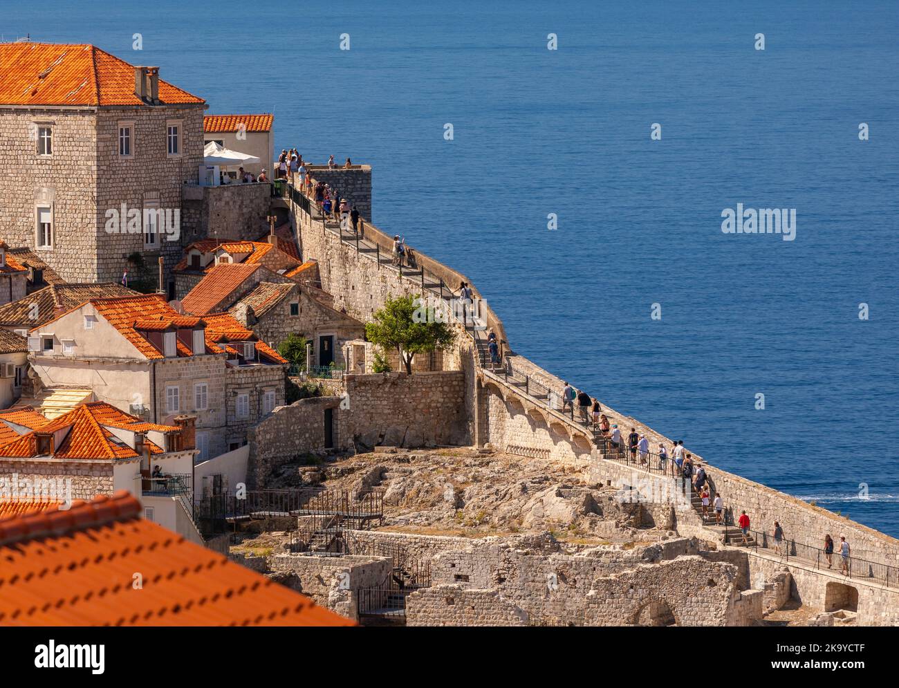 DUBROVNIK, CROATIA, EUROPE - Tourists walk the wall in fortress city of Dubrovnik on the Dalmation coast. Stock Photo