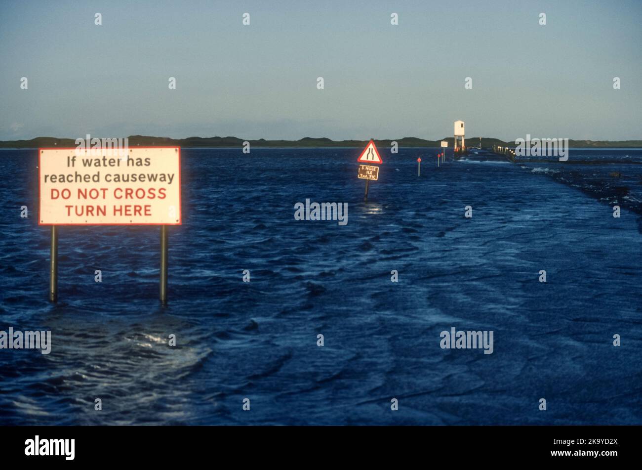 Warning signs on Lindisfarne causeway at high tide. Stock Photo