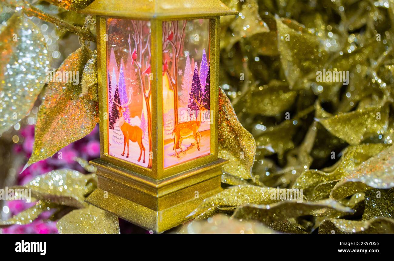Christmas decoration in the form of a gold lantern with pink light and