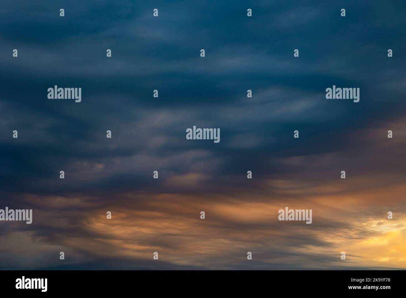 Dramatic clouds at sunrise. Weather background photo. Blue and orange clouds. Stock Photo