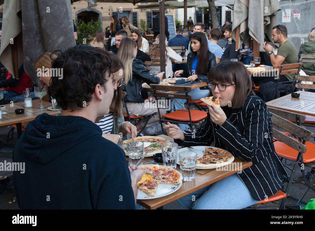 A young couple eat pizza at the Fany & Mary restaurant in Ljubjlana, Slovenia Stock Photo