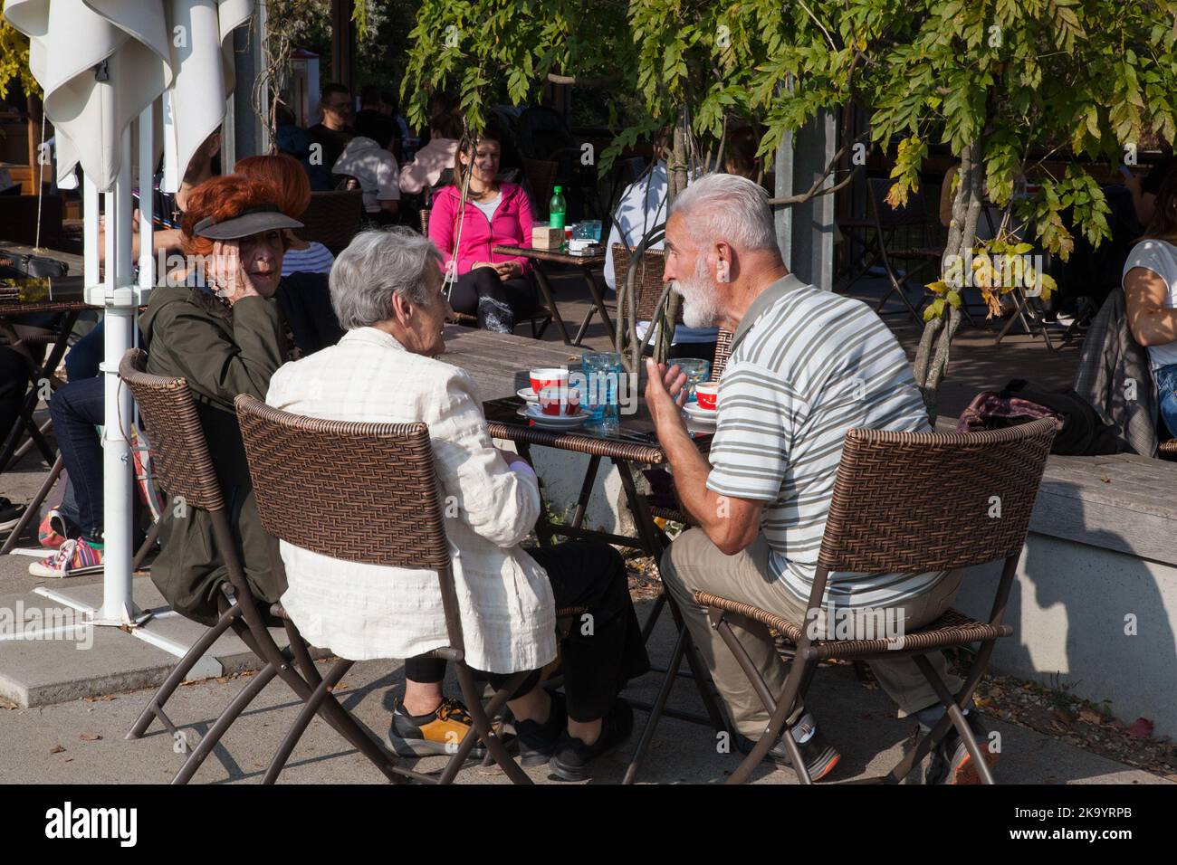 An elderly couple in conversation at Čolnarna cafe in Tivoli Park, Ljubljana, Slovenia Stock Photo