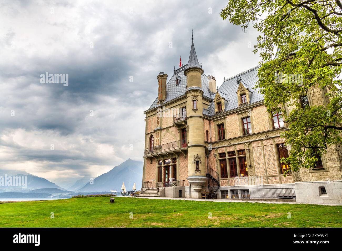 19th century Gothic Revival style Schadau Castle in Schadau Park overlooking Lake Thun and the Alps, Thun, Switzerland Stock Photo