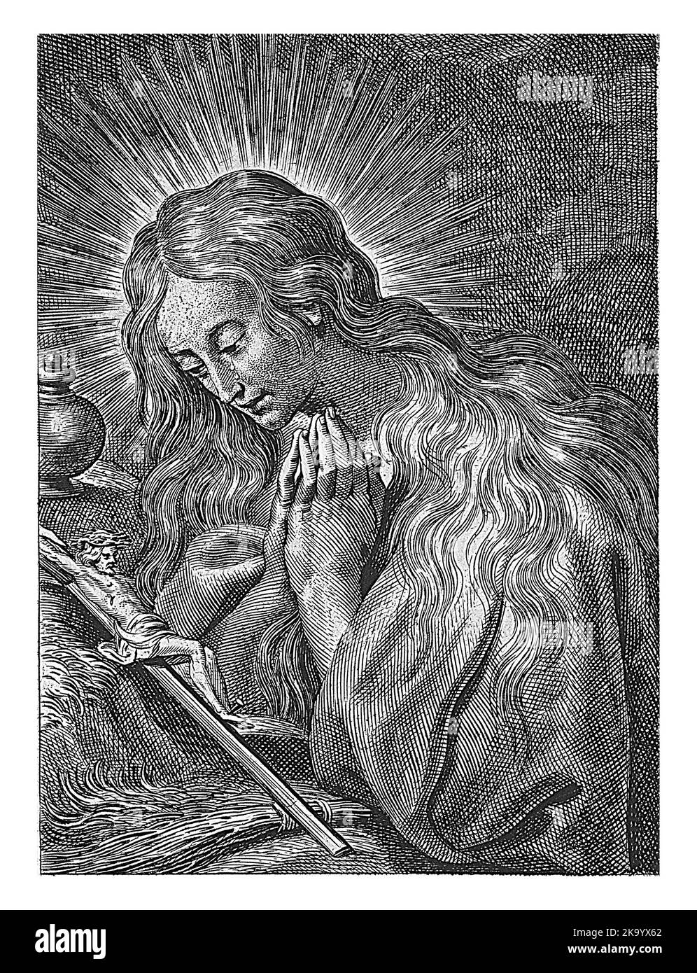 Mary Magdalene prays kneeling before crucifix. Stock Photo