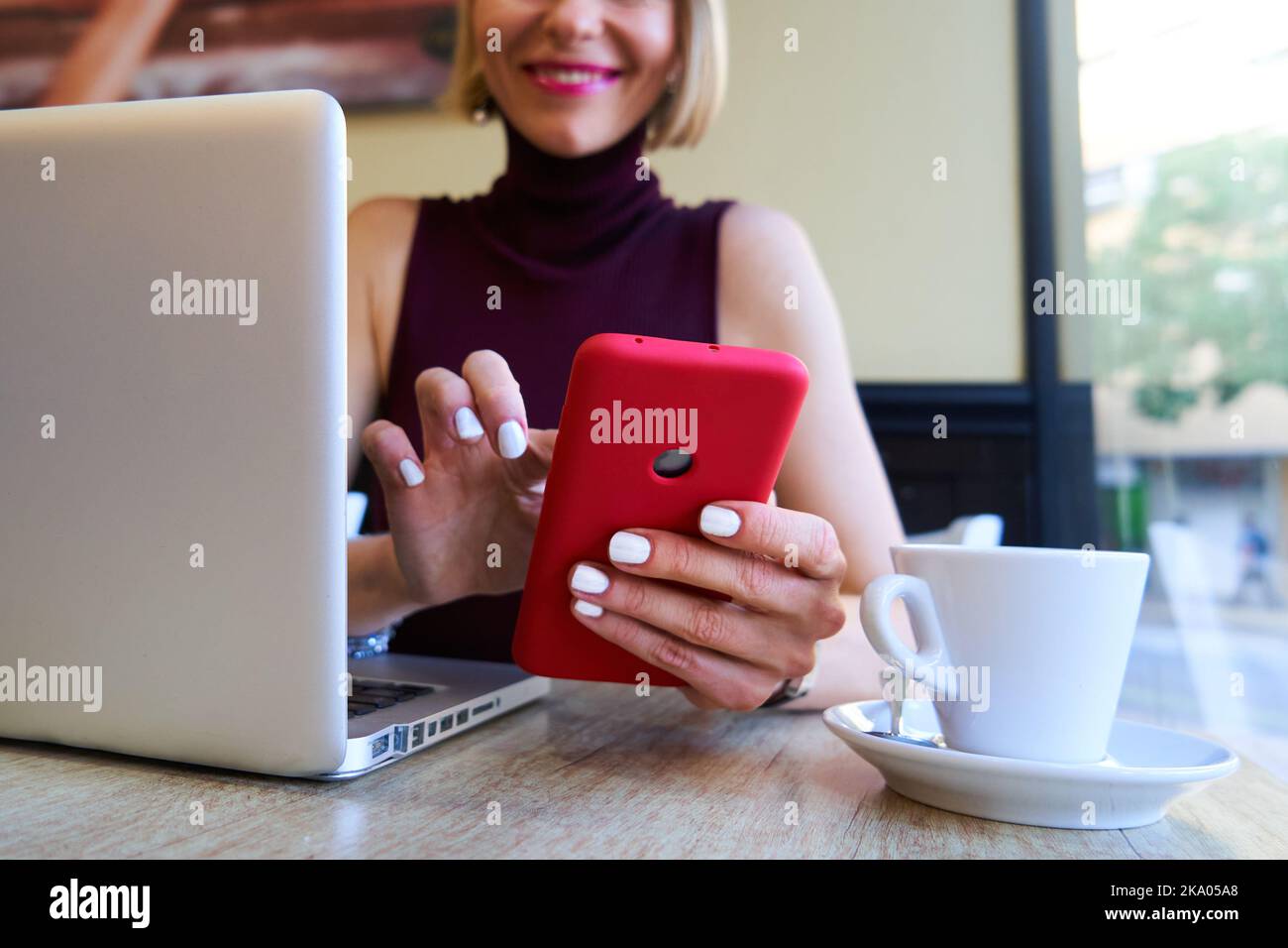 Close up photo of a caucasian woman hands using smart phone to work from distance in a coffee shop Stock Photo