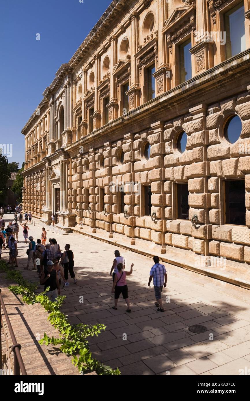 Tourists walking past the palace of Charles the V on the Alhambra palace grounds, Granada, Spain. Stock Photo
