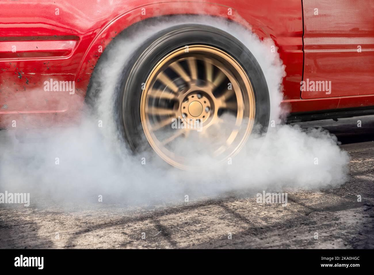 Drag racing car burning tire at starting line in race track Stock Photo