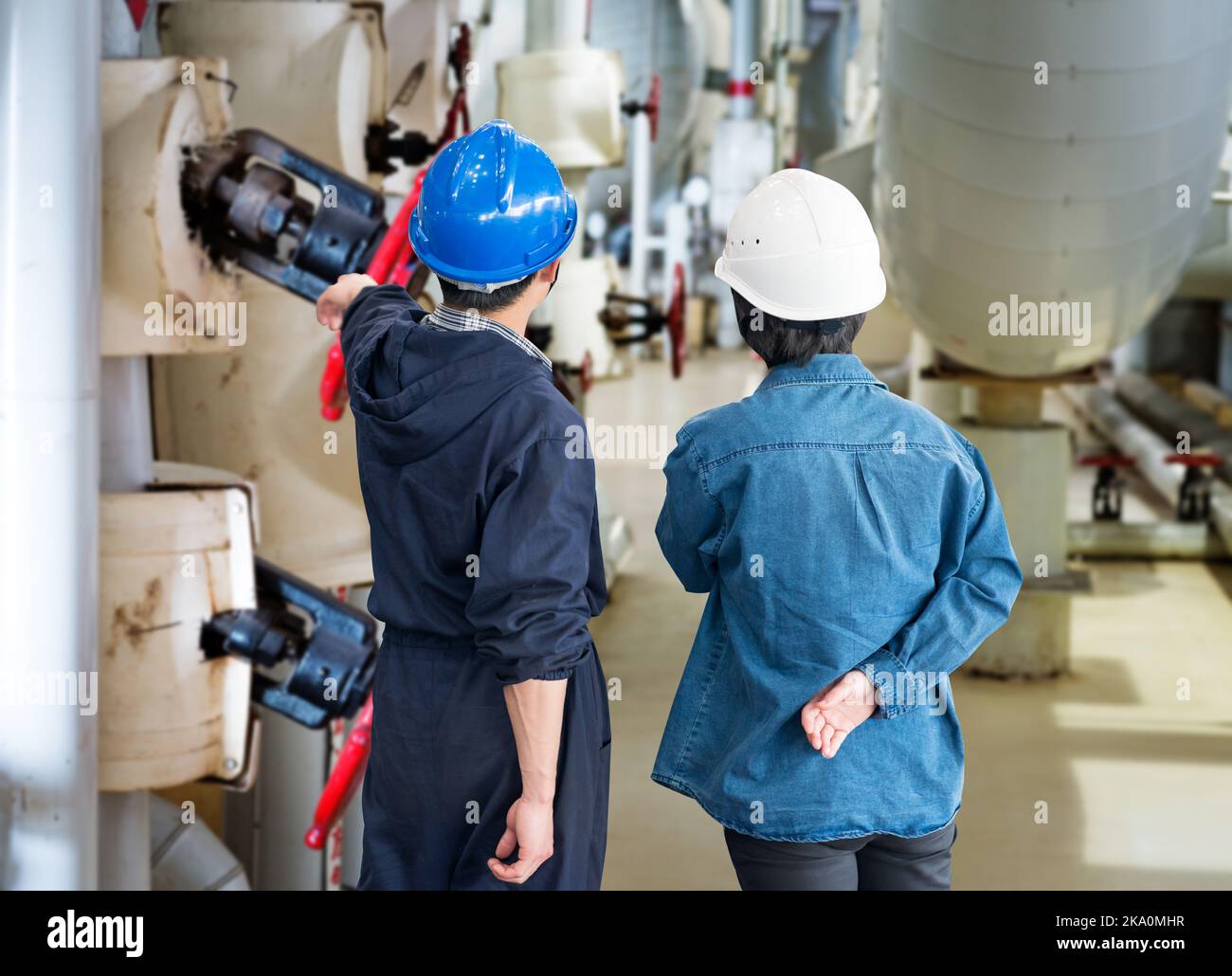 A team of construction workers with helmets at work place in a factory Stock Photo
