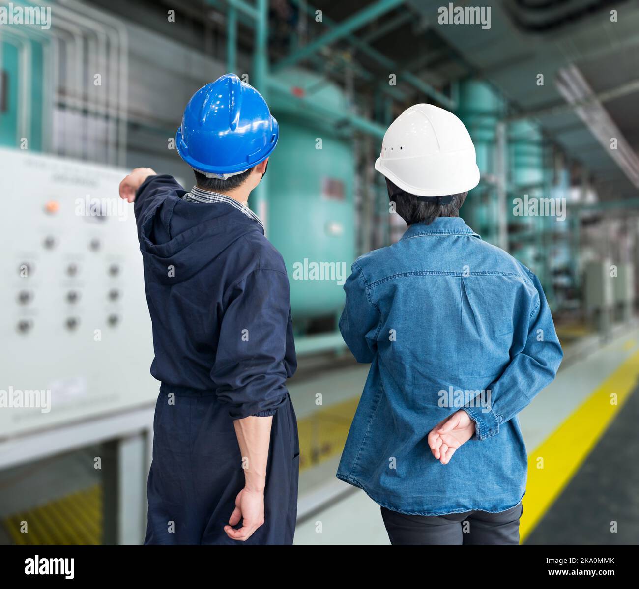 A team of construction workers with helmets at work place in a factory Stock Photo