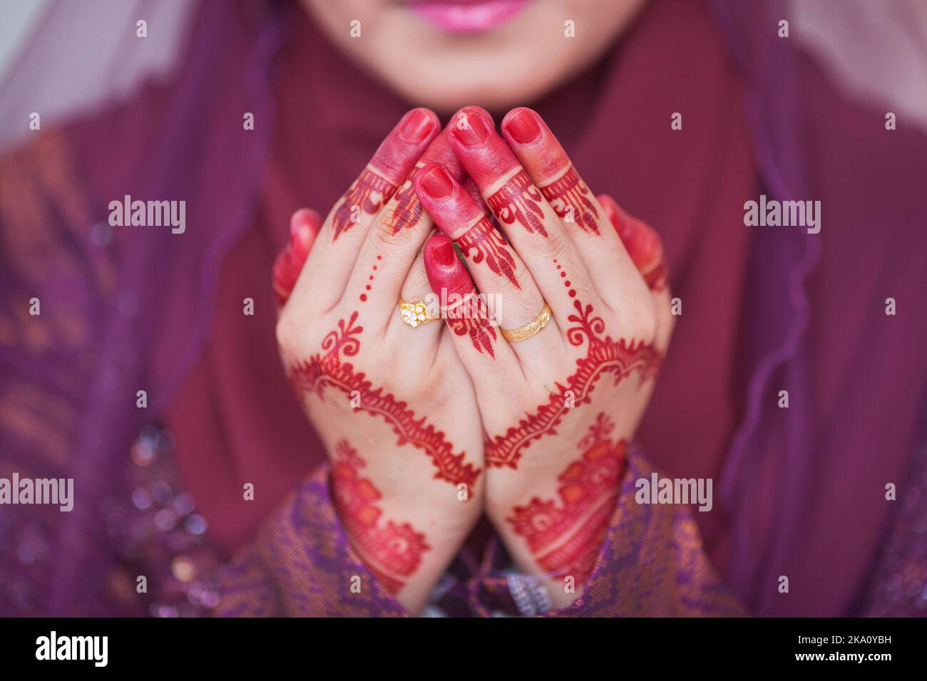 Henna and wedding ring on bride hand, pray for doa session Stock Photo