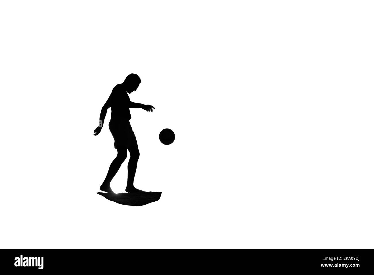 Silhouette of a man playing football Stock Photo