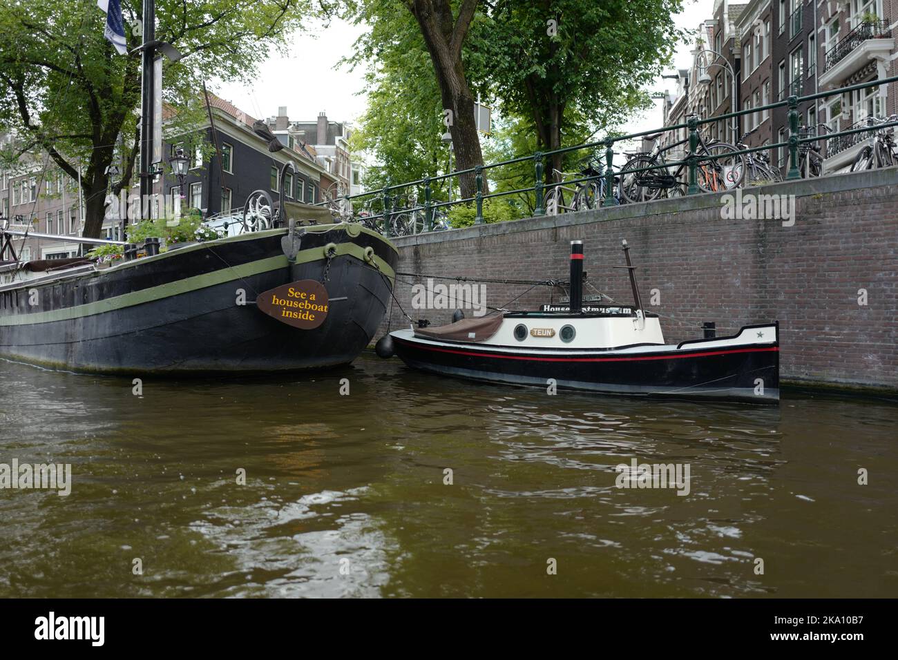 Small boat with smoke stack in Amsterdam Stock Photo