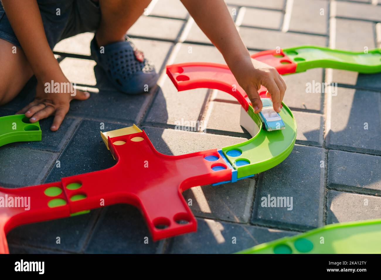 Closeup view of a boy's hands playing outside in the garden of the house with multicolored and