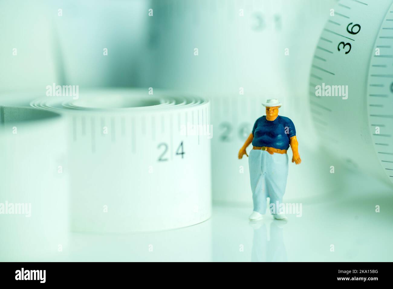 miniature figure of an obese man against measuring tape. Stock Photo