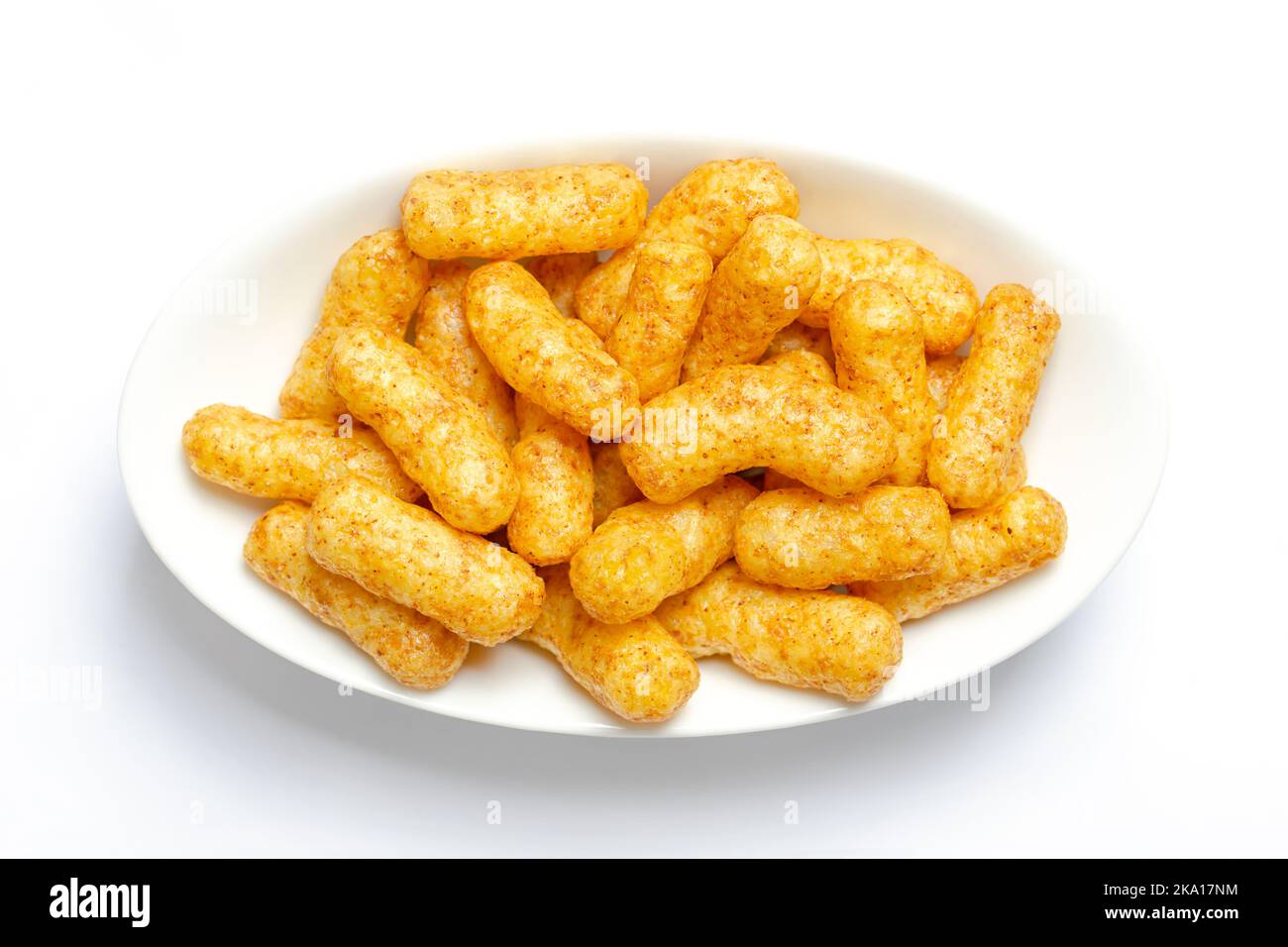 Peanut flips, in a white bowl. Also known as Bamba, peanut puffs or snips, is a puffed, peanut-flavored corn snack. Stock Photo