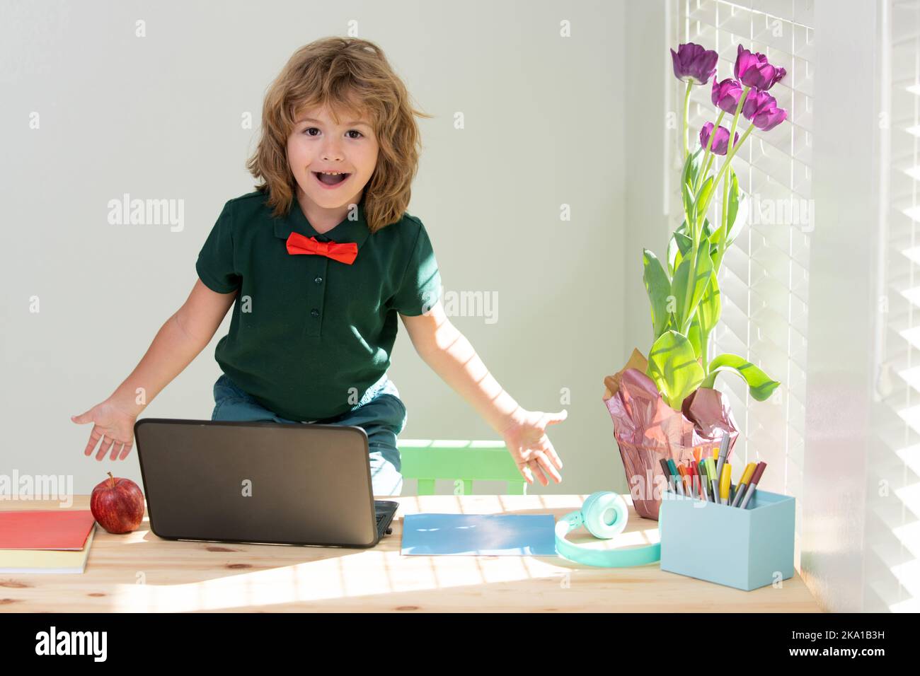 Schoolboy doing homework. Funny child learns with laptop in study room ...