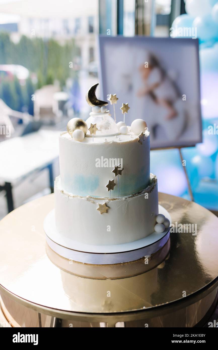 Beautiful cake for Christening. White cake decorated by stars from sugar. Gold stand Stock Photo