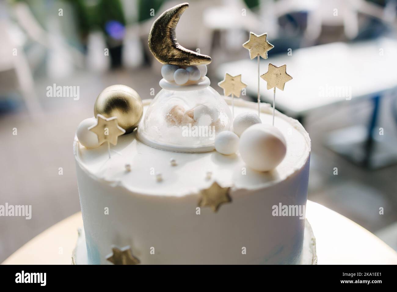 Close-up of beautiful cake for Christening. White cake decorated by stars from sugar. Gold stand Stock Photo