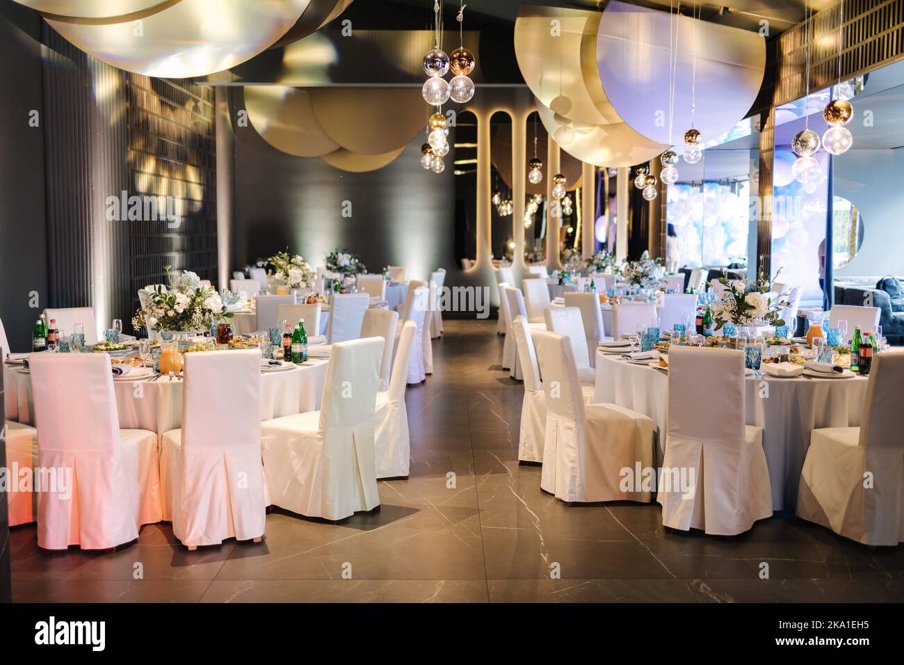 Luxury decor in restaurant. Round table with different elements of decor. Beautiful flowers and table setting Stock Photo