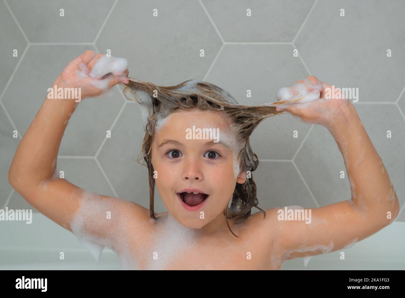 Kid Washing Hair Boy Child In A Bath With Foam Kids Bathing And Hygiene Procedures Bath Tub With Soap Bubble Funny Kids Face 2KA1FG3 