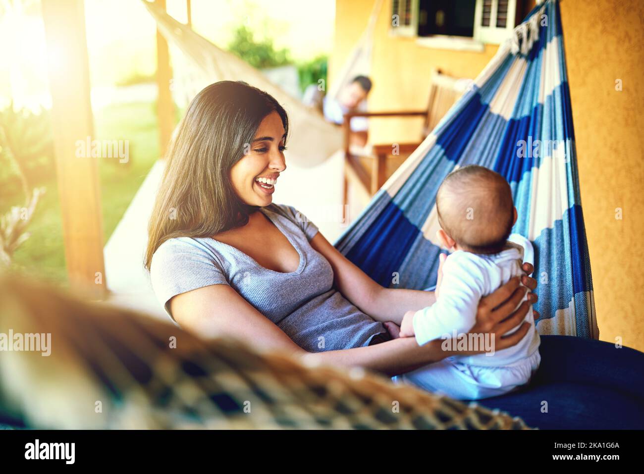 Bonding with the newborn. a cheerful young mother holding her baby infant son while smiling at him outside at home. Stock Photo