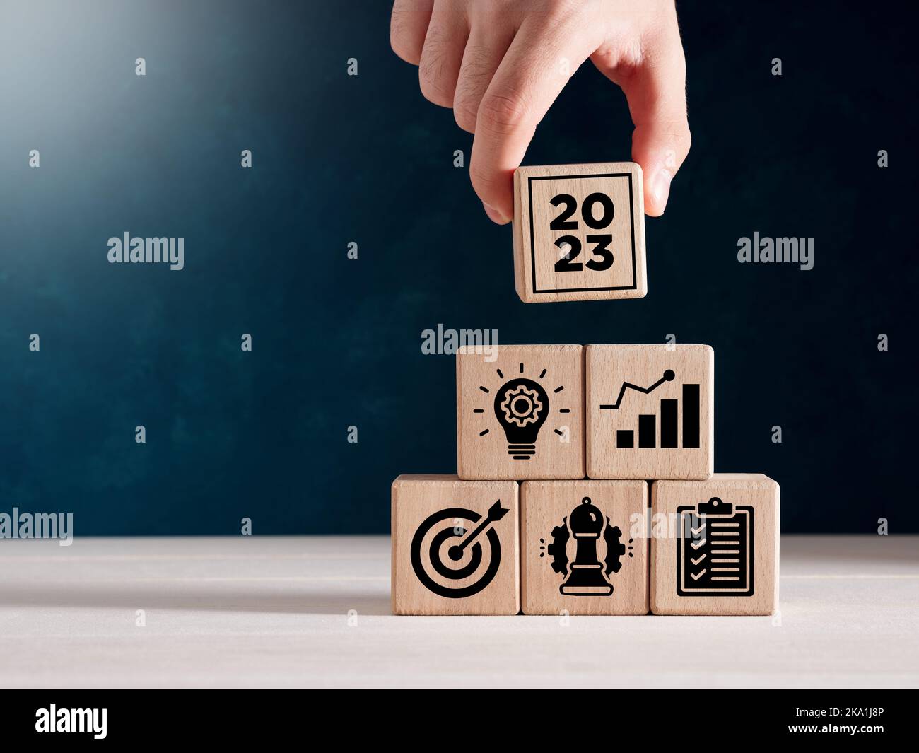 Year 2023 business goals, strategy, action plan and vision concept Business development or achieving business goals. Hand puts the stacked wooden cube Stock Photo