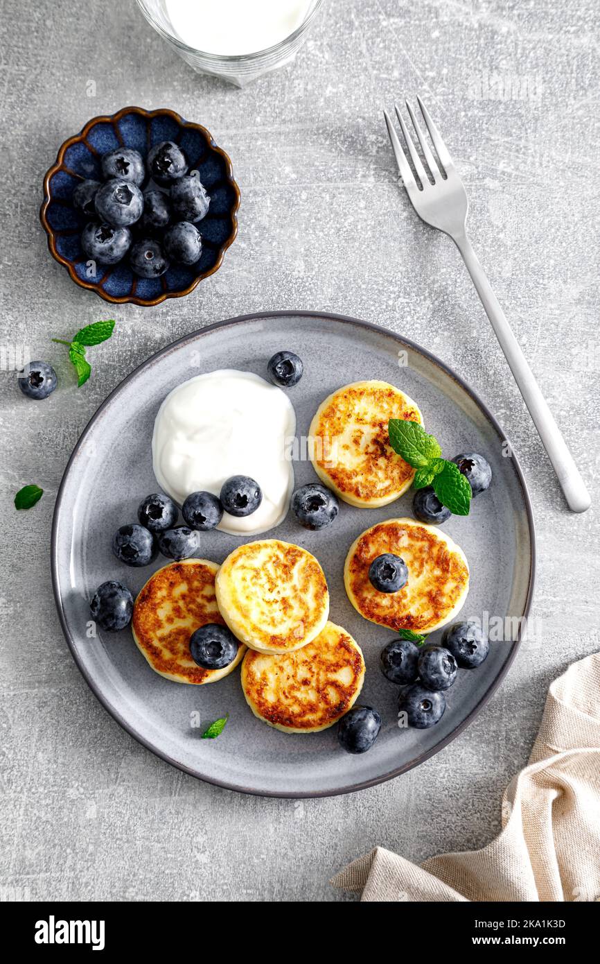 Cottage cheese fritters with fresh blueberry and yogurt for breakfast, view from above Stock Photo