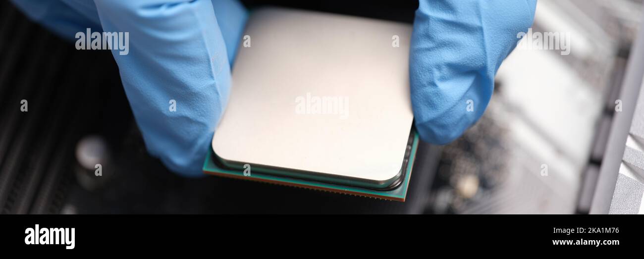 Technician examines microprocessor chip on PC motherboard Stock Photo