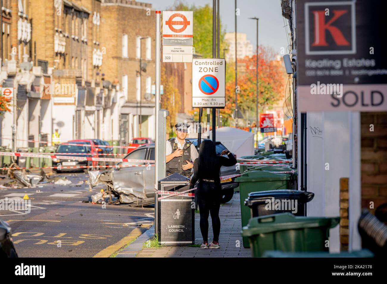A police officer speaks with local residents the morning after two