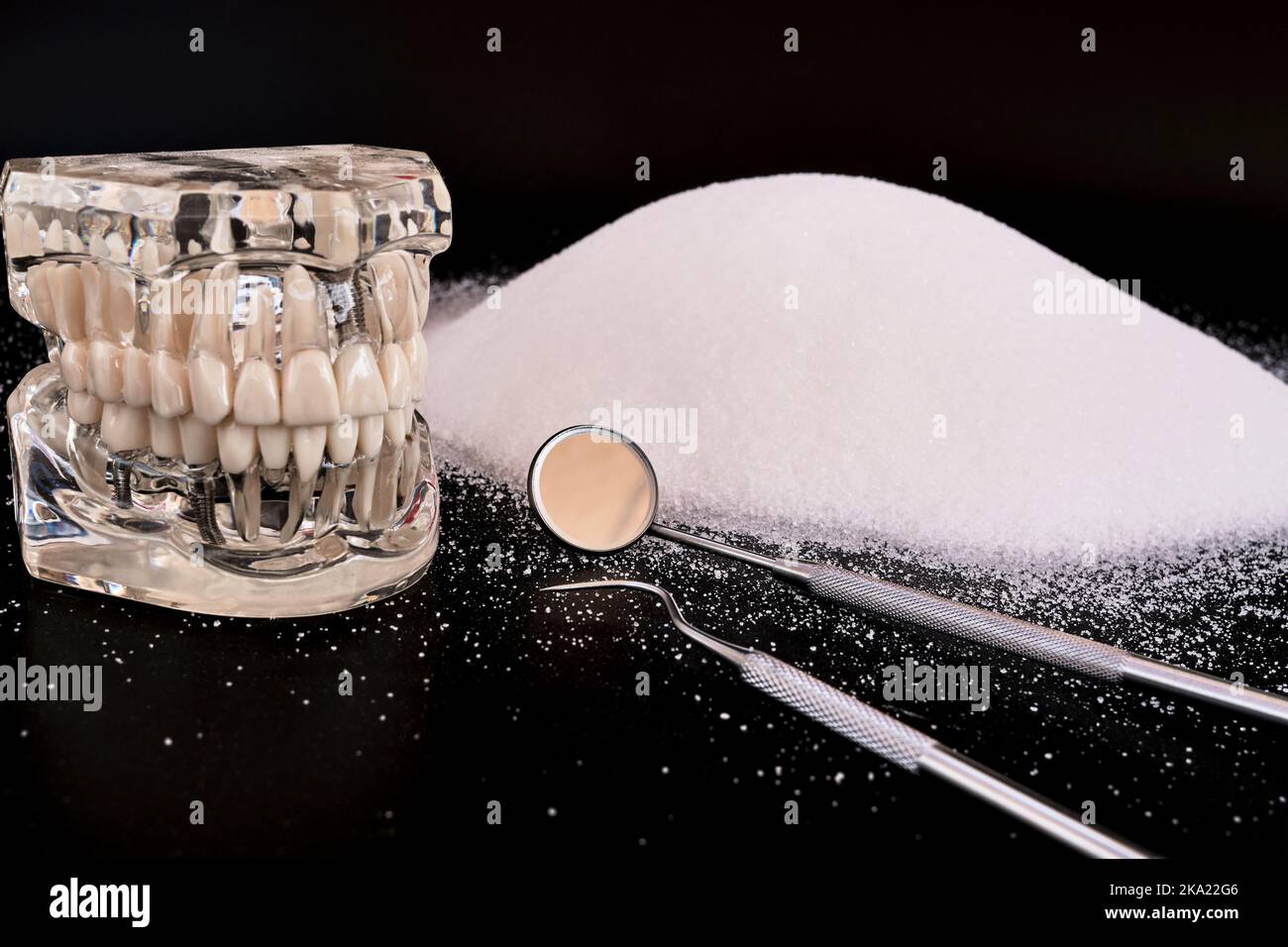 Dentist's mirror and hook on heap of white sugar, caries concept Stock