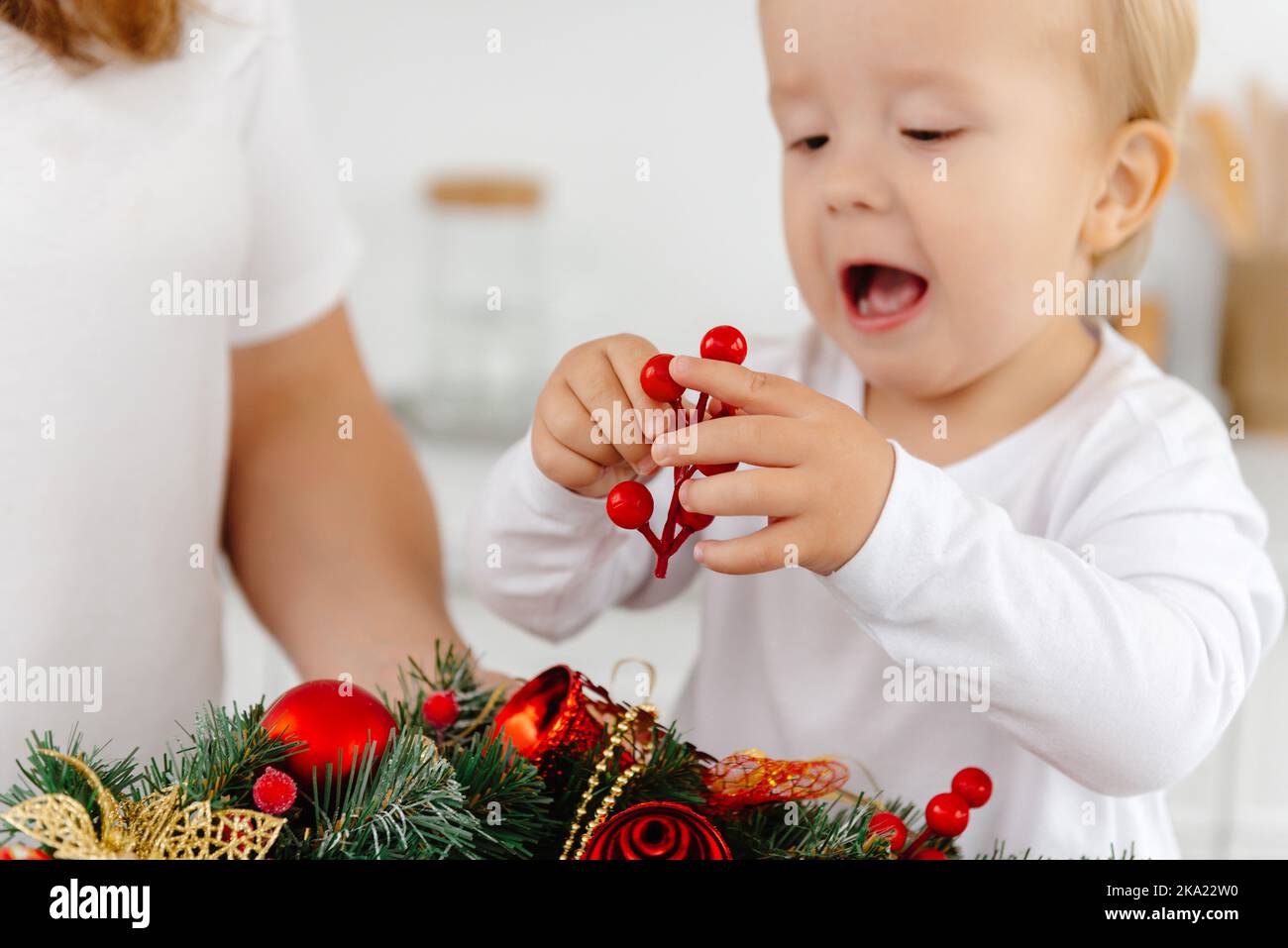 little helper son helps mom with Christmas decorations Stock Photo