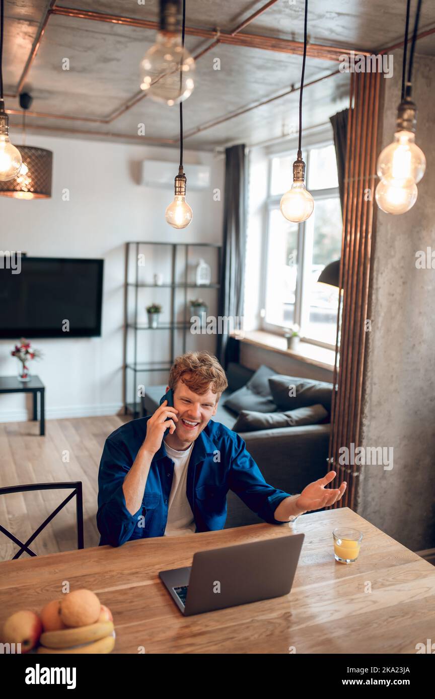 Young man in the home office having a phone call Stock Photo