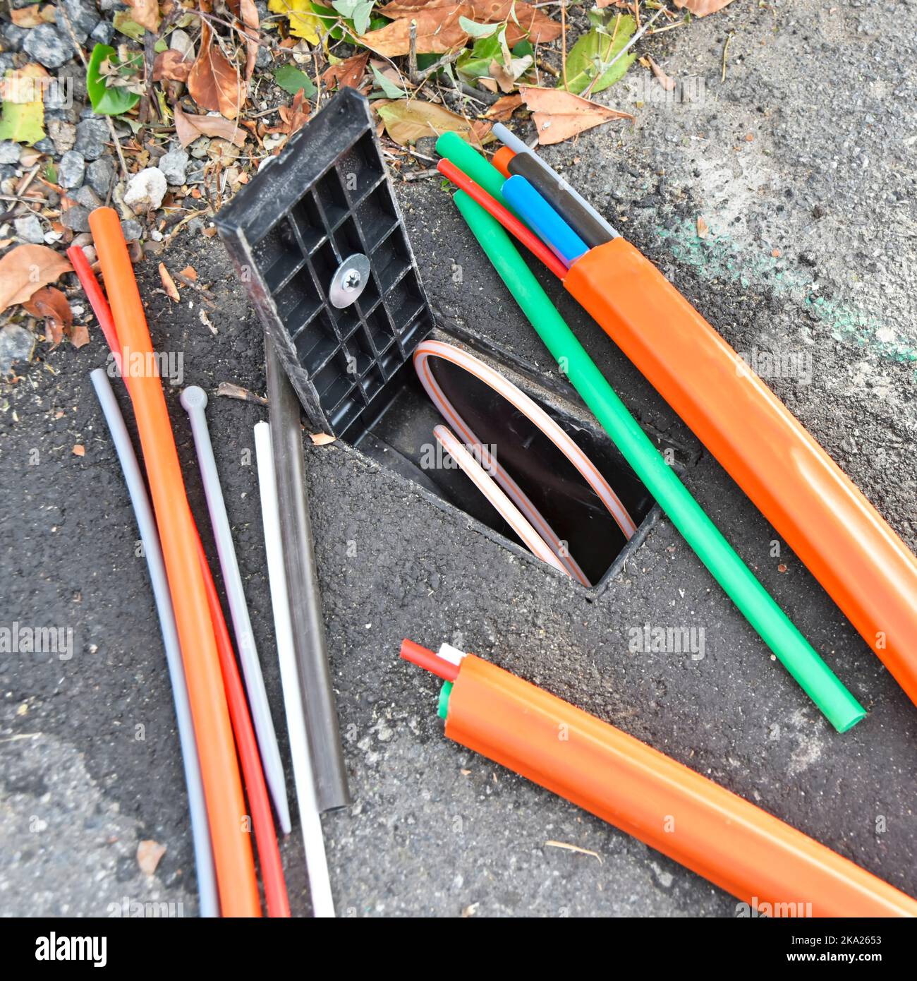 Fibre optic broadband discarded random cable offcuts beside open consumer junction box just illustration & connected customer cable ready if wanted UK Stock Photo