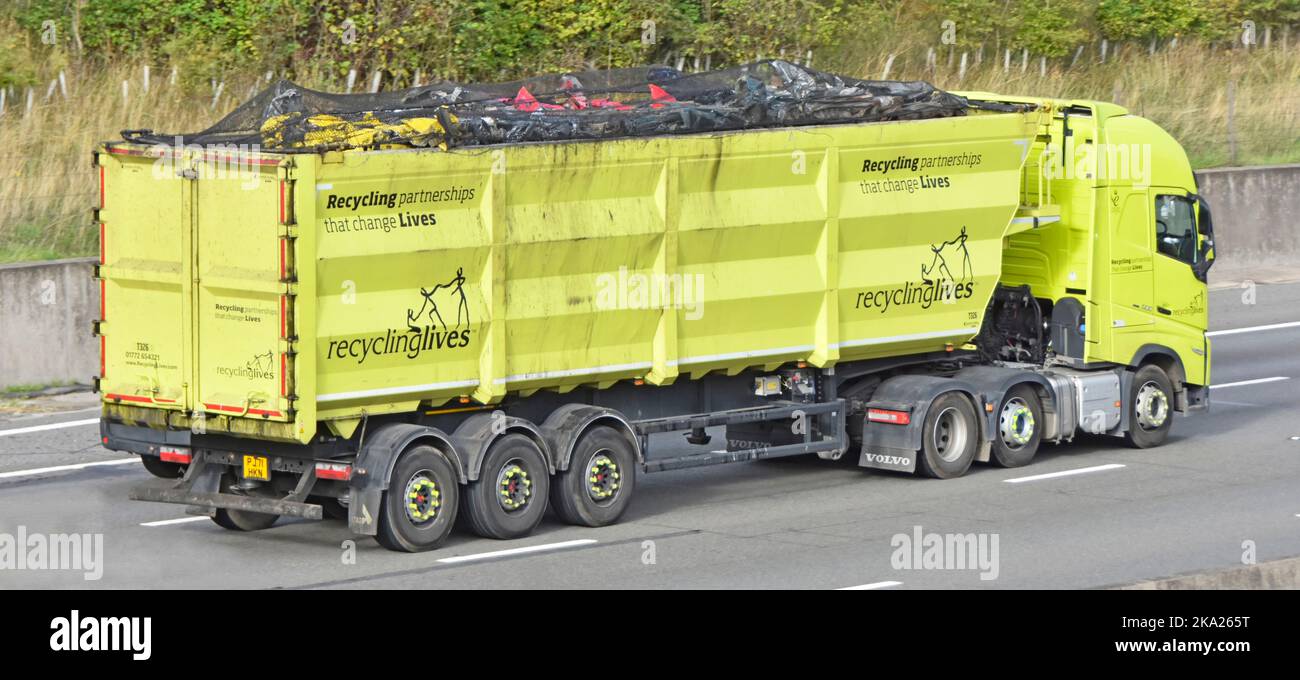 Yellow combination of Volvo 500 hgv lorry truck & articulated trailer  loaded with scrap metal side view of slogans recycling changes lives England UK Stock Photo