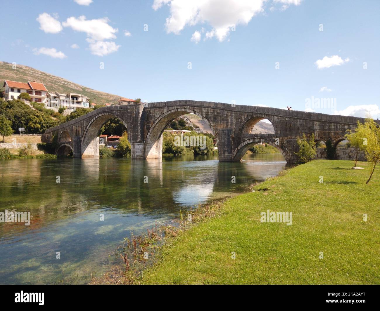 An arched old stone bridge over the river Stock Photo - Alamy