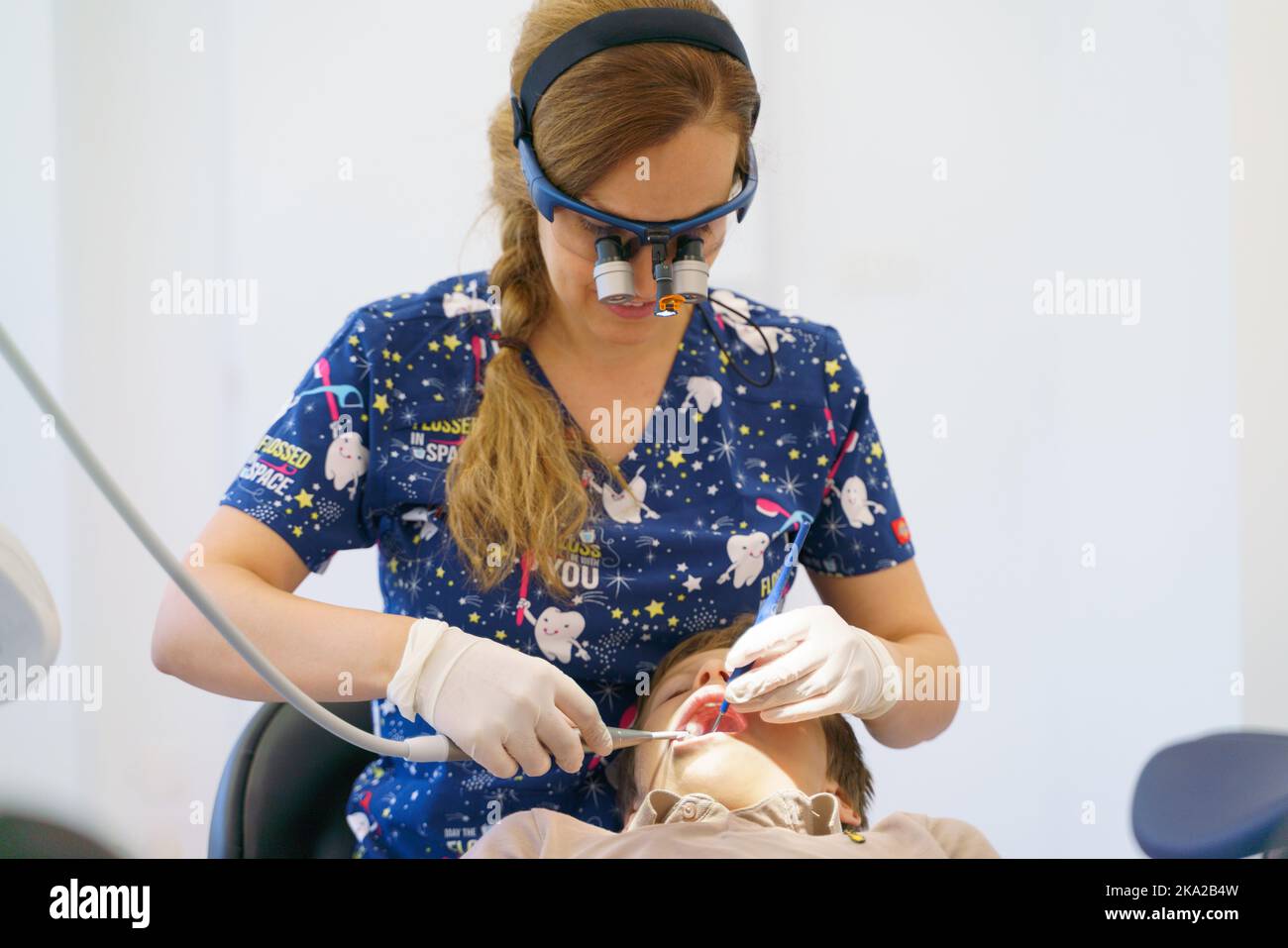 Young woman dentist doing doing preventive examination little boy. Stock Photo