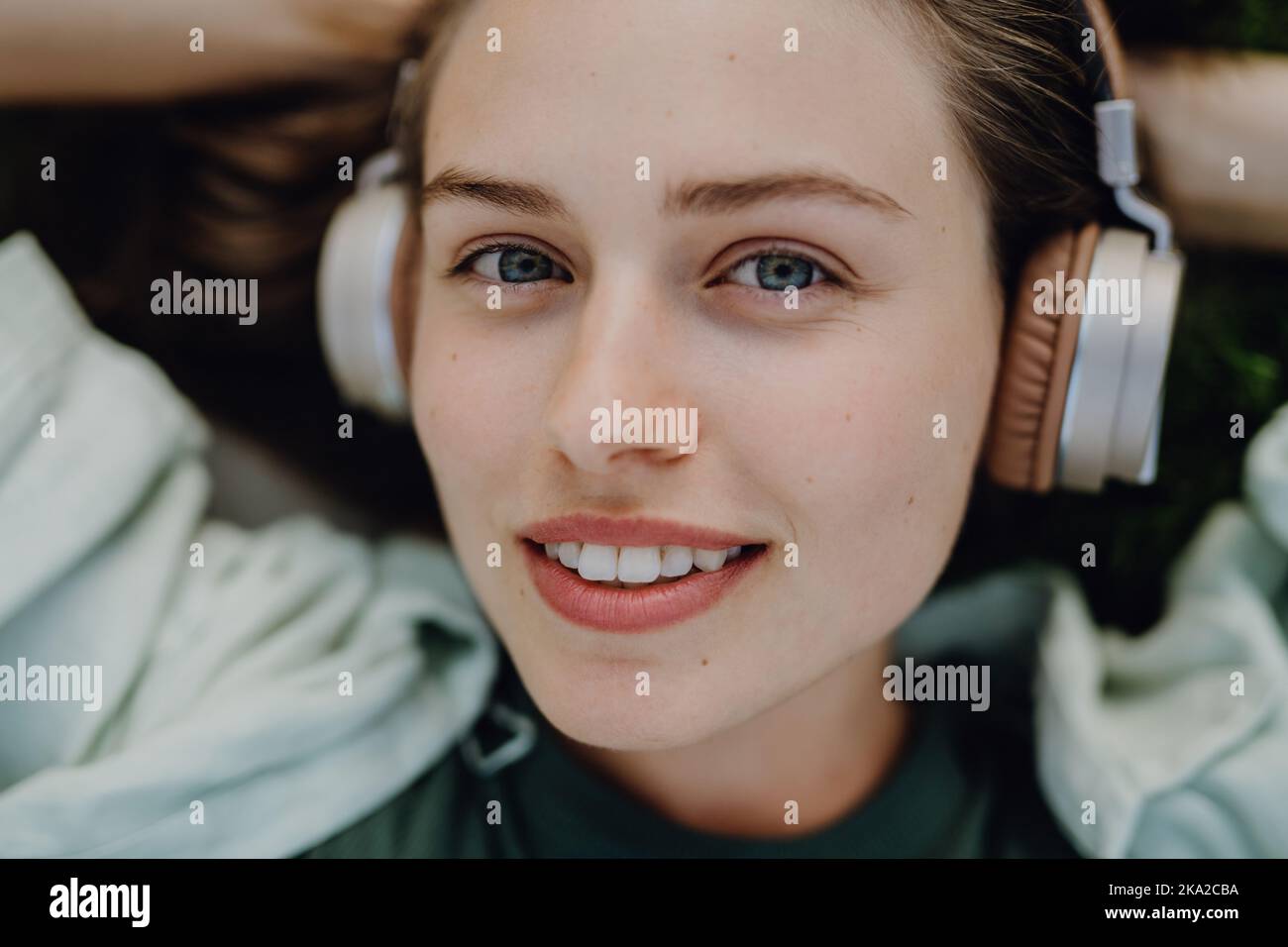 Portrait of young woman listening music trough headphones Stock Photo ...
