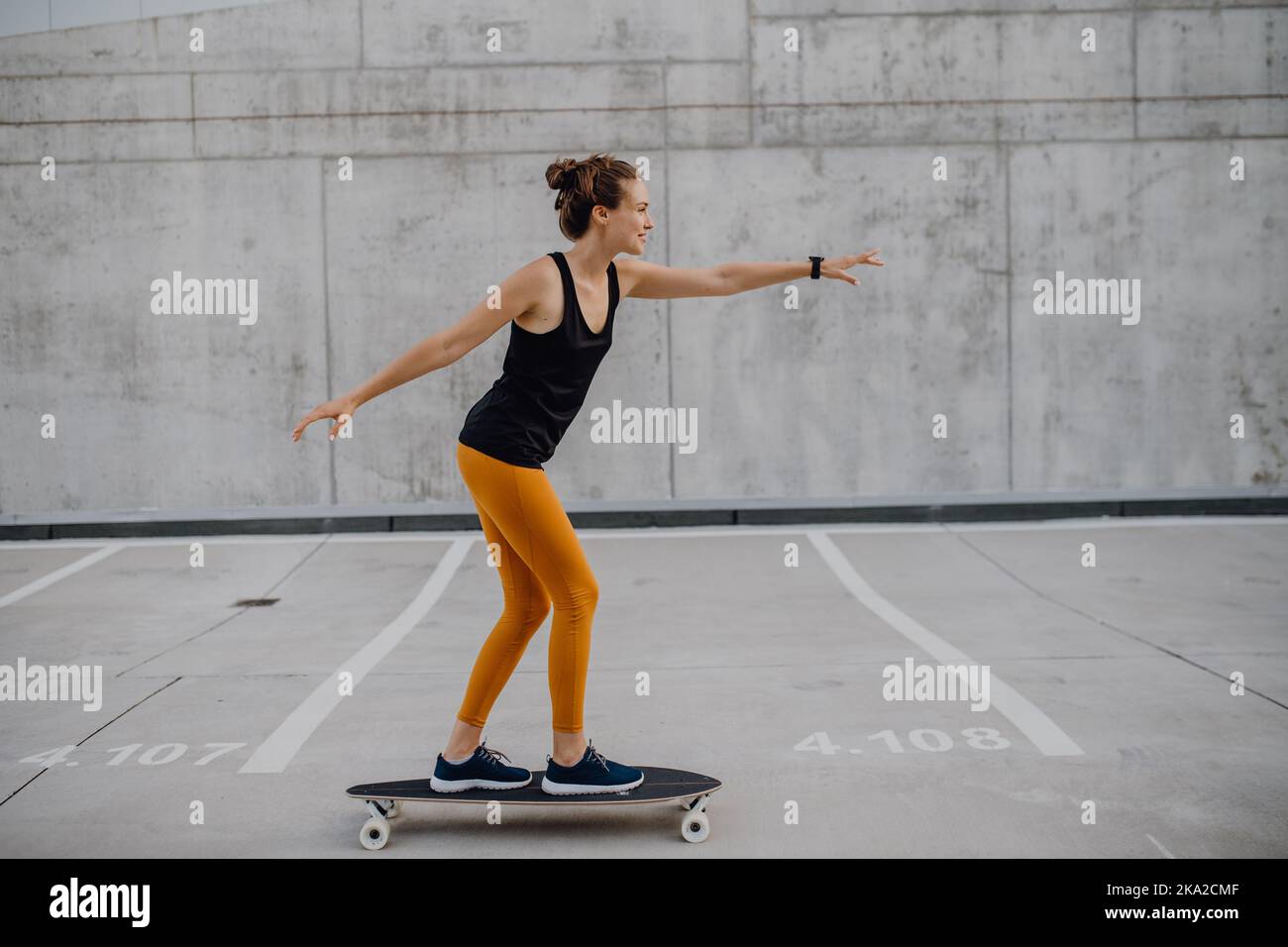 Young woman ridding skateboard at city. Youth culture and commuting concept. Stock Photo