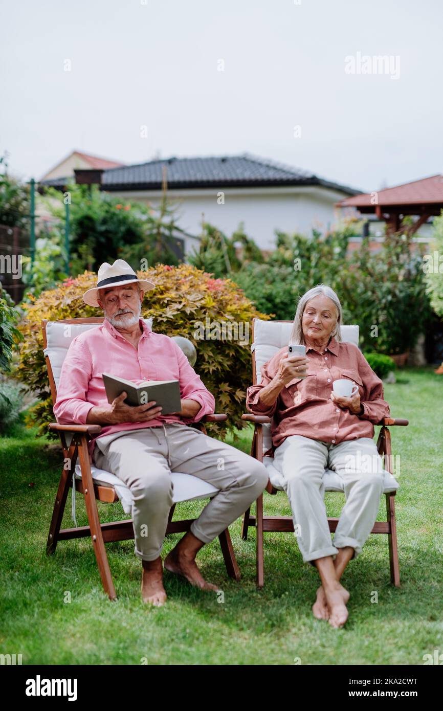 Happy couple relaxing together in their garden Stock Photo - Alamy
