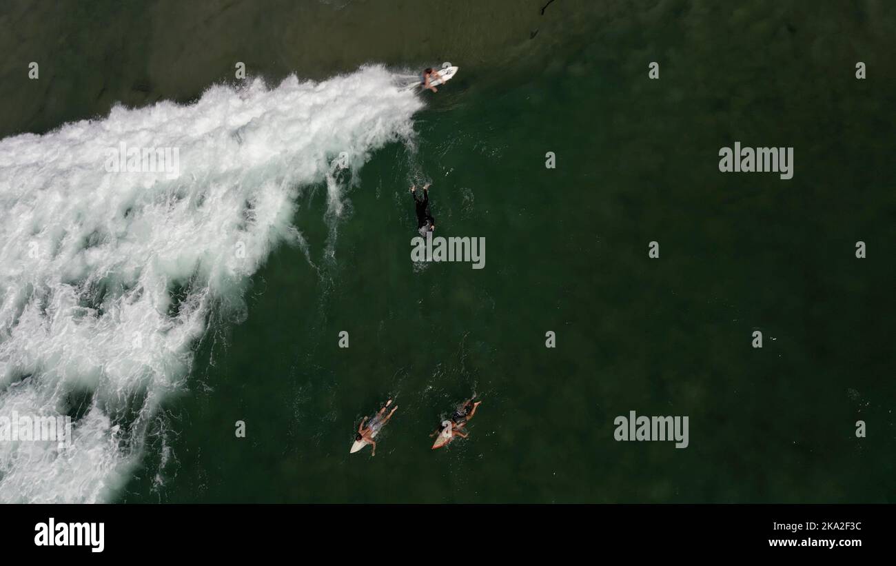 A stunning view of surfers catching a wave Stock Photo Alamy