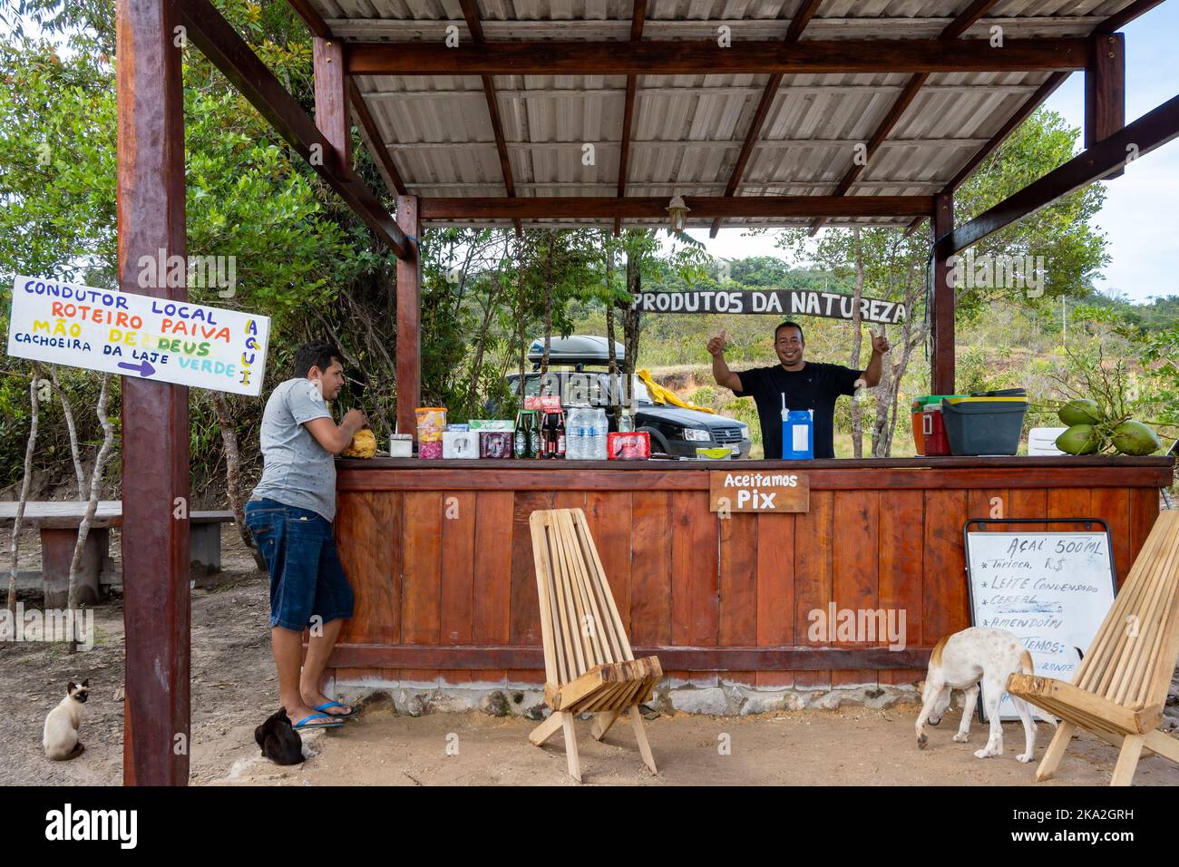 A man selling snacks and cold drinks at a roadside stand. Tepequém, Roraima State, Brazil. Stock Photo